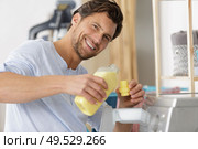 man doing laundry - washing machine. Стоковое фото, агентство Ingram Publishing / Фотобанк Лори