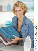 woman is ironing towels on ironing board. Стоковое фото, агентство Ingram Publishing / Фотобанк Лори