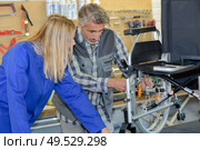 a man is assembling a wheelchair. Стоковое фото, агентство Ingram Publishing / Фотобанк Лори