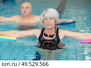 portrait of senior man and woman in swimming pool. Стоковое фото, агентство Ingram Publishing / Фотобанк Лори