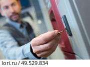 close up of man inserting coin into vending machine. Стоковое фото, агентство Ingram Publishing / Фотобанк Лори