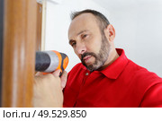 hardworker man drilling wooden frame. Стоковое фото, агентство Ingram Publishing / Фотобанк Лори