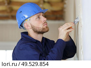 construction worker with long trowel plastering a wall. Стоковое фото, агентство Ingram Publishing / Фотобанк Лори