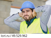 construction worker covering ears outdoors. Стоковое фото, агентство Ingram Publishing / Фотобанк Лори