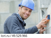 masonry construction worker levels the wall. Стоковое фото, агентство Ingram Publishing / Фотобанк Лори