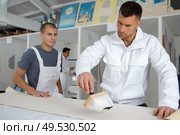 decorator brushing wallpaper with glue. Стоковое фото, агентство Ingram Publishing / Фотобанк Лори