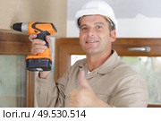 a happy construction worker assembles a window. Стоковое фото, агентство Ingram Publishing / Фотобанк Лори
