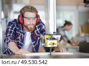 joiner wearing protection working on a wooden piece. Стоковое фото, агентство Ingram Publishing / Фотобанк Лори