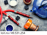 Details of tobacco hookah and teapot with tea.Egyptian smoking shisha and teakettle. Oriental hookah with kettle. Стоковое фото, агентство Ingram Publishing / Фотобанк Лори