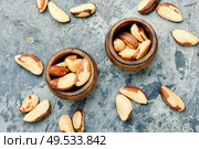 Wooden retro mortar filled with Brazil nut. Brazil nut or Bertholletia. Стоковое фото, агентство Ingram Publishing / Фотобанк Лори