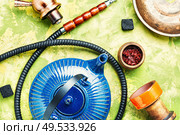 Details of tobacco hookah and teapot with tea.Egyptian smoking shisha and teakettle. Arabic shisha with teakettle. Стоковое фото, агентство Ingram Publishing / Фотобанк Лори