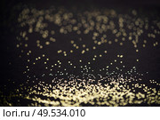 Beautiful Christmas shimmering light background. Abstract glitter bokeh and scattered sparkles in gold, on black. Beautiful Christmas light background. Abstract glitter bokeh and scattered sparkles in gold, on black. Стоковое фото, агентство Ingram Publishing / Фотобанк Лори