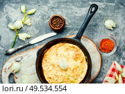 Frying pan with scrambled eggs stuffed with edible yucca flowers.American food. Omelet with edible flowers. Стоковое фото, агентство Ingram Publishing / Фотобанк Лори