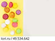 Border of fresh fresh macaroon biscuit, top view over yellow and beige background. Fresh macaroon confection. Стоковое фото, агентство Ingram Publishing / Фотобанк Лори
