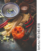 Homemade kimchi preparation. Fermented chinese cabbage marinated in hot chili sauce in jar on rustic background with ingredients. Top view. Healthy asian food. Стоковое фото, агентство Ingram Publishing / Фотобанк Лори