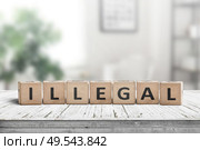Illegal message on a wooden desk in a bright living room in daylight. Стоковое фото, агентство Ingram Publishing / Фотобанк Лори