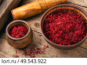 Raw organic red saffron spice on wooden background. Dried saffron spice. Стоковое фото, агентство Ingram Publishing / Фотобанк Лори
