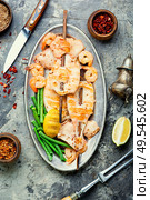 Grilled squid or calamari on skewer.Barbecue squids on a plate.. Grilled squid on a skewer. Стоковое фото, агентство Ingram Publishing / Фотобанк Лори