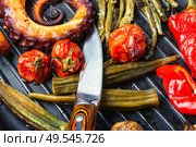 Grilled octopus with roasted vegetables in grill pan.Seafood.. Grilled octopus on the grill. Стоковое фото, агентство Ingram Publishing / Фотобанк Лори