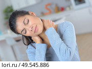 young woman feeling exhausted and suffering from neck pain. Стоковое фото, агентство Ingram Publishing / Фотобанк Лори