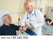 doctor bandaging male patients wrist. Стоковое фото, агентство Ingram Publishing / Фотобанк Лори