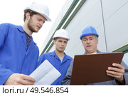 group of builders in hardhats with clipboard outdoors. Стоковое фото, агентство Ingram Publishing / Фотобанк Лори