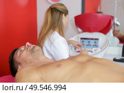 woman waxing mans chest. Стоковое фото, агентство Ingram Publishing / Фотобанк Лори