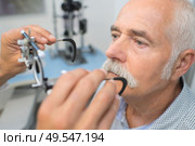 senior man having sight test at optometrist. Стоковое фото, агентство Ingram Publishing / Фотобанк Лори