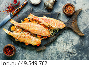 Mullet fish fried with horseradish rootsSpicy fry fish on cutting board. Fried fish with horseradish roots. Стоковое фото, агентство Ingram Publishing / Фотобанк Лори