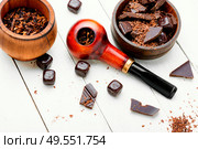 Chocolate flavored tobacco for smoking pipes.Tobacco pipe filled with tobacco.. Smoking pipe with tobacco leaves. Стоковое фото, агентство Ingram Publishing / Фотобанк Лори