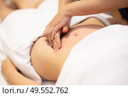 Woman receiving a belly massage at spa salon. Female patient is receiving treatment by professional osteopathy therapist.. Woman receiving a belly massage at spa salon. Стоковое фото, агентство Ingram Publishing / Фотобанк Лори