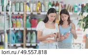 Uncertain mother and daughter choosing nail polish in store during summer. Стоковое видео, видеограф Яков Филимонов / Фотобанк Лори
