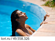 Beautiful Arab woman relaxing in swimming pool with eyes closed. Girl with healthy tanned skin and wet hair enjoying Summer Sun.. Beautiful Arab woman relaxing in swimming pool. Стоковое фото, агентство Ingram Publishing / Фотобанк Лори