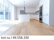 Modern trendy kitchen design with white cabinets. Subway tile backsplash, marble countertop. No brands or labels. Neutral contemporary design. Simply furniture with utensils, crockery, refrigerator. Стоковое AI-изображение, AI-художник Марина Демидюк / Фотобанк Лори