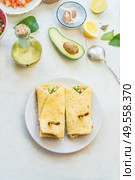 Tasty tortilla wraps sandwiches with avocado and fresh vegetables ingredients on light table background, top view. Healthy food.  Vegetarian lunch or snack. Стоковое фото, агентство Ingram Publishing / Фотобанк Лори