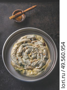 Preparation of stuffed savory pastry  pie with phyllo dough in traditional baking pan on dark rustic background. Top view. Balkan or oriental cuisine. Home cooking. Burek making. Ramadan food. Стоковое фото, агентство Ingram Publishing / Фотобанк Лори