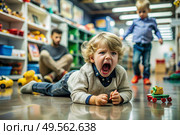 A little boy is lying on the floor in a store. Childish hysteria. The child screams, sobs, gets cranky and gets hysterical. Discontent. Стоковое AI-изображение, AI-художник Photojuli / Фотобанк Лори