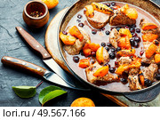 Baked meat in red wine with apricot and blackcurrant.Stewed pork in iron cast pan. Stew meat with apricot. Стоковое фото, агентство Ingram Publishing / Фотобанк Лори