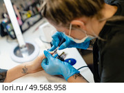 Close-up of Beautician painting her client’s nails in blue and yellow nail varnish in a beauty centre. Close-up of Beautician painting her client’s nails in blue and yellow nail varnish. Стоковое фото, агентство Ingram Publishing / Фотобанк Лори
