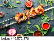 Appetizing shashlik on skewers with nettle marinade.. Kebabs,grilled meat with nettles. Стоковое фото, агентство Ingram Publishing / Фотобанк Лори
