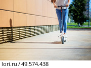 Detail of girl circulating in the city with an electric scooter. Woman circulating in the city with an electric scooter. Стоковое фото, агентство Ingram Publishing / Фотобанк Лори