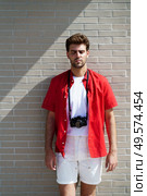 Millennial man traveling with a SLR camera outdoors. Male with eyes closed.. Man traveling with a SLR camera outdoors. Male with eyes closed. Стоковое фото, агентство Ingram Publishing / Фотобанк Лори