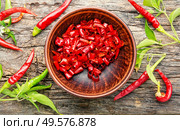 Sliced red hot chili peppers on on wooden background. Paprika powder and chili peppe. Стоковое фото, агентство Ingram Publishing / Фотобанк Лори