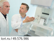 senior doctors discussing next to machine in hospital. Стоковое фото, агентство Ingram Publishing / Фотобанк Лори