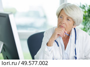 portrait of a senior woman doctor looking at screen. Стоковое фото, агентство Ingram Publishing / Фотобанк Лори