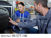 mechanics checking tread on tyre. Стоковое фото, агентство Ingram Publishing / Фотобанк Лори
