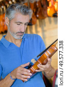portait of man checking the violin components. Стоковое фото, агентство Ingram Publishing / Фотобанк Лори