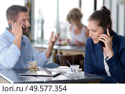 executive couple in a cafe both talking on smartphones. Стоковое фото, агентство Ingram Publishing / Фотобанк Лори