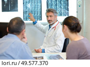Doctor explaining xrays to couple. Стоковое фото, агентство Ingram Publishing / Фотобанк Лори