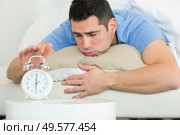 upset man trying to wake up from the bed. Стоковое фото, агентство Ingram Publishing / Фотобанк Лори
